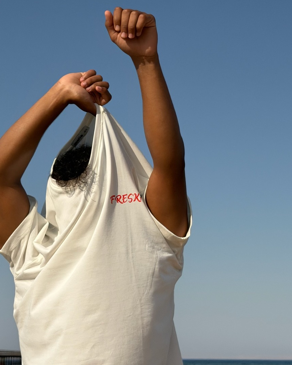 Freska oversized tee by Meilo — held up at the beach, 100% Egyptian cotton